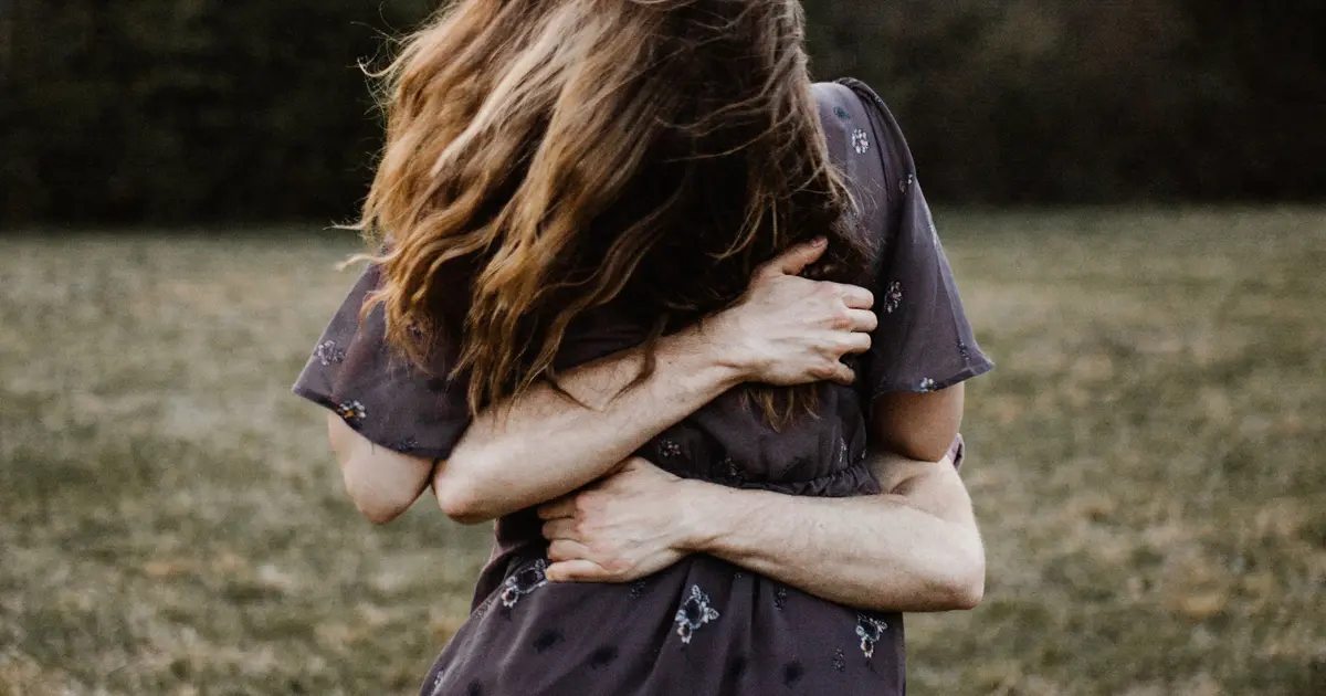Woman being comforted through a hug