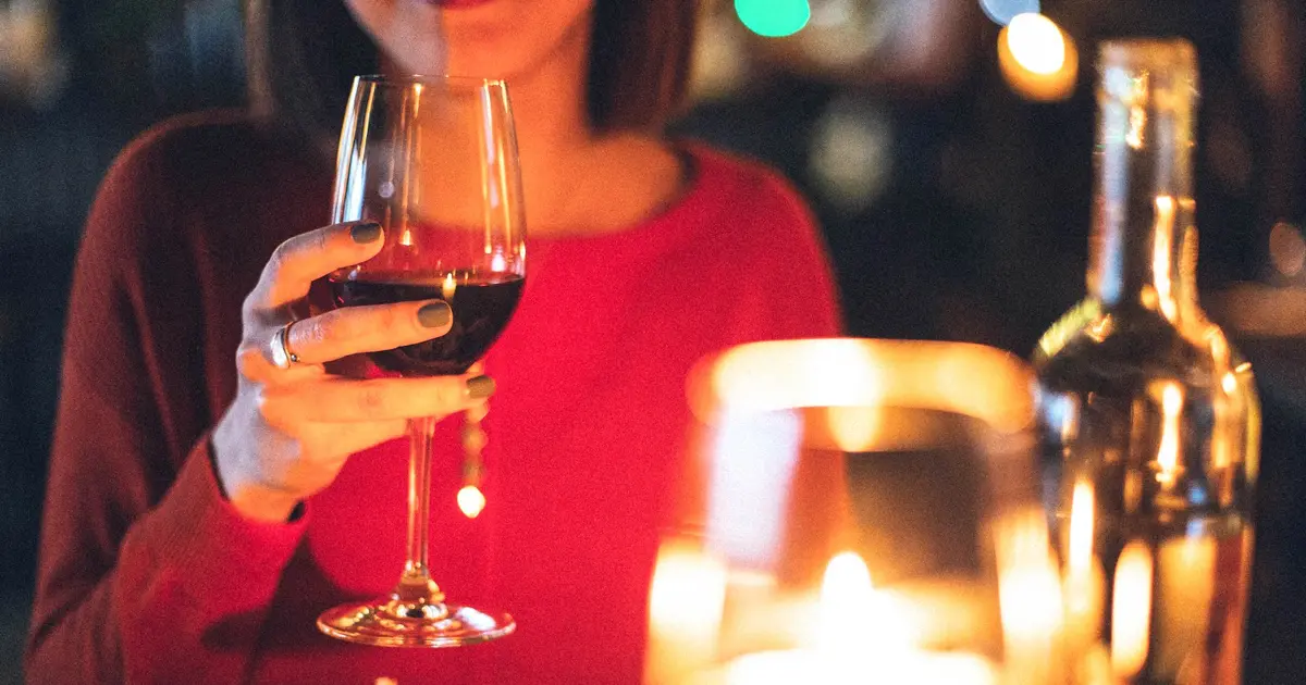 A woman drinking good wine for beginners during a date.