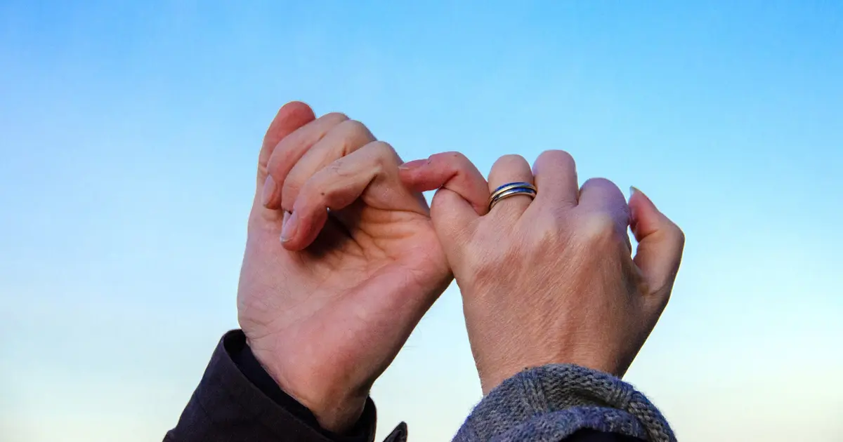 Two hands joined together to make a pinky promise