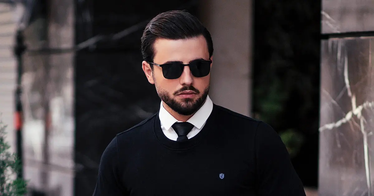 A man wearing a sweater and sunglasses.
